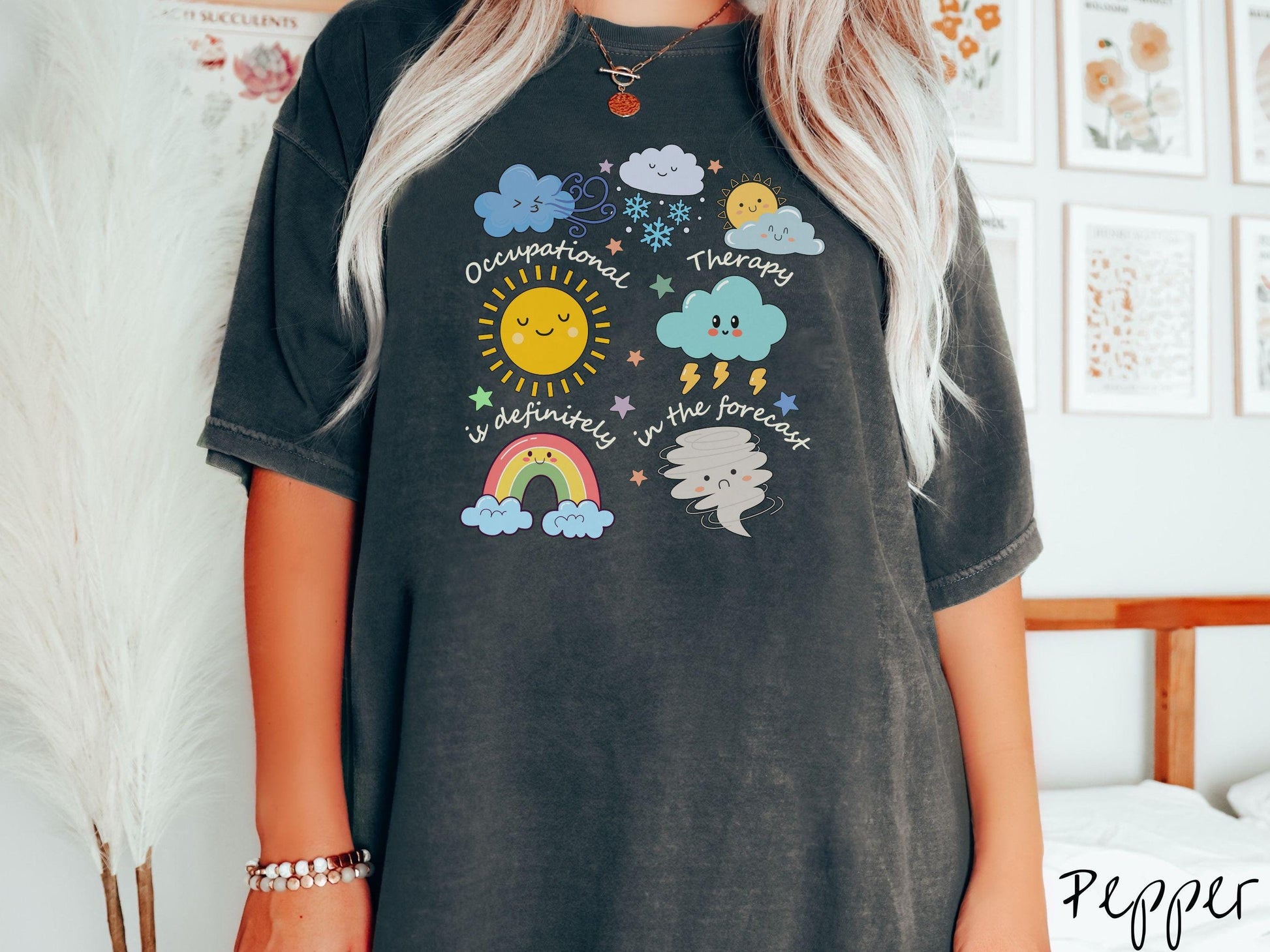 A vintage, pepper colored Comfort Colors T-shirt featuring the text Occupational Therapy is definitely in the forecast and surrounded by weather elements like clouds, rain clouds, a shining sun, lightning, a rainbow, and a tornado.