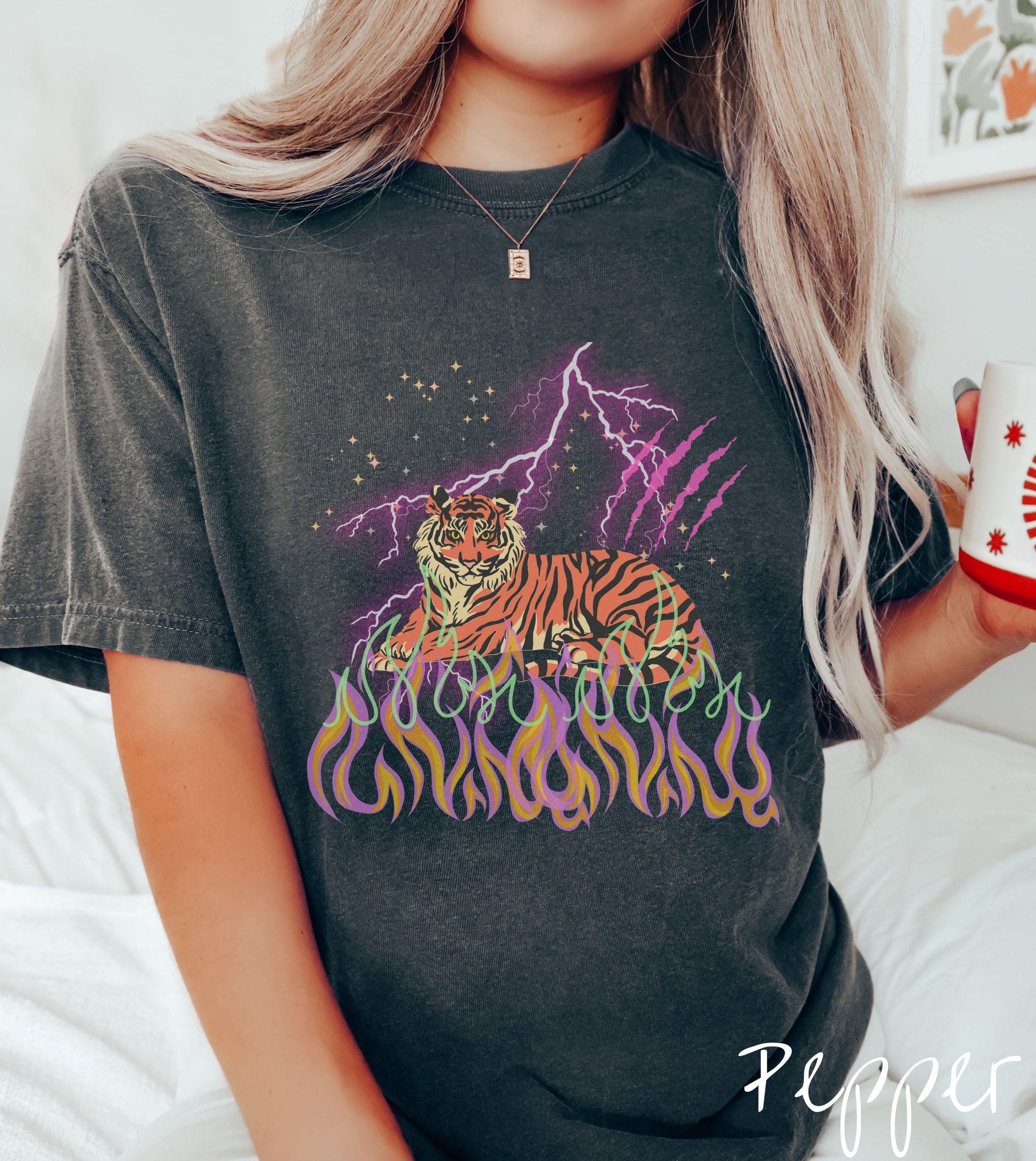 A vintage Comfort Colors t-shirt with a majestic tiger design above colorful flames and lightning. The relaxed fit and classic crew neckline make it perfect for casual or semi-formal wear.