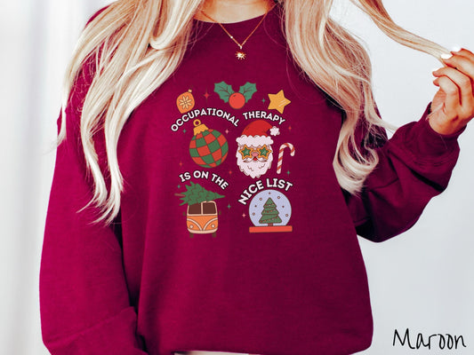 A vintage maroon colored Gildan sweatshirt features the text &#39;Occupational Therapy is on the nice list&#39; in white font, surrounded by Christmas lights, cranberries, Santa Claus, a candy cane, a snow globe,and other festive decorations.