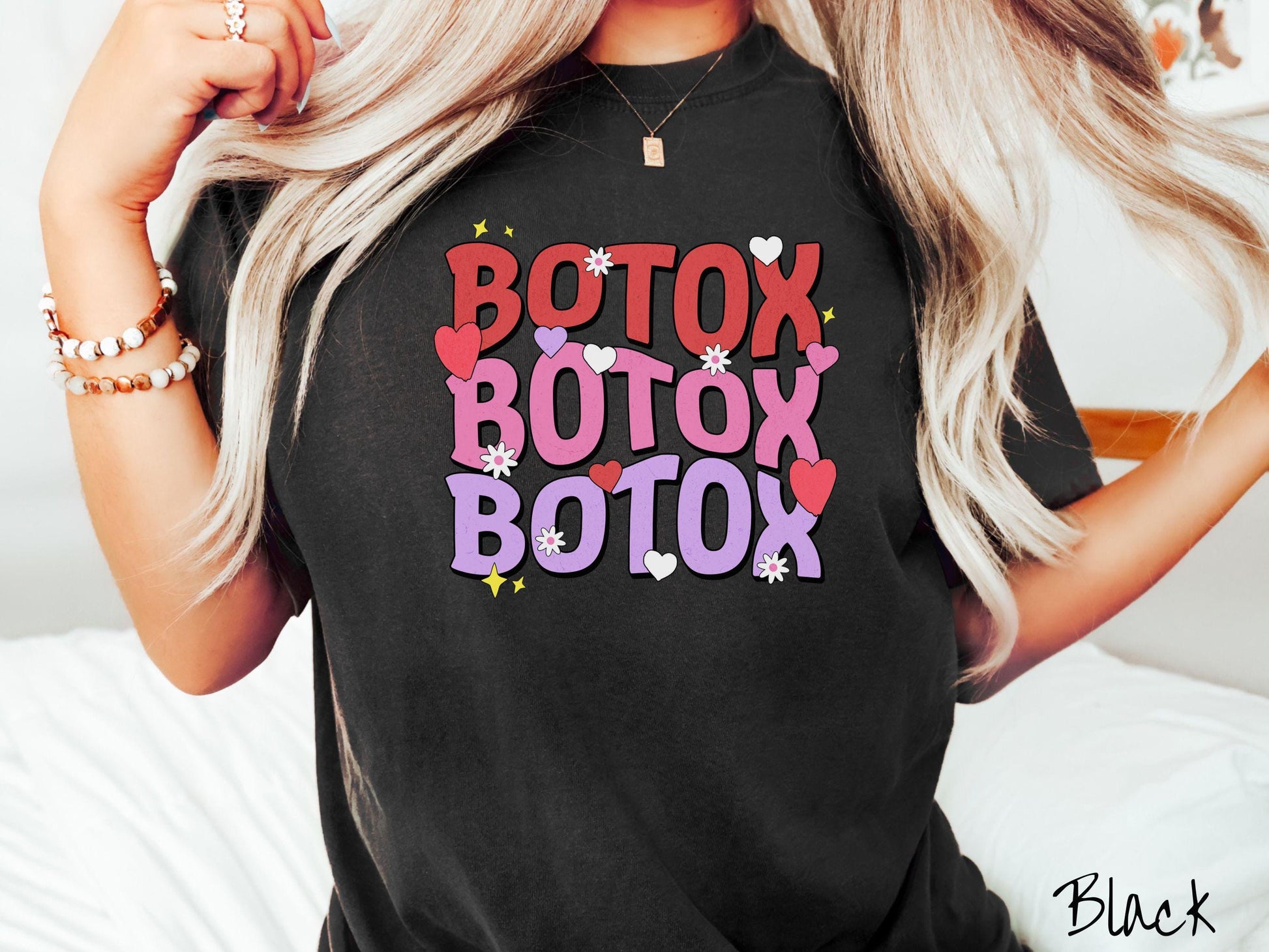 A vibrant Comfort Colors T-shirt with the text BOTOX written three times vertically, accompanied by tiny hearts, stars, and flowers. The perfect gift for friends who are into cosmetic botox nursing.