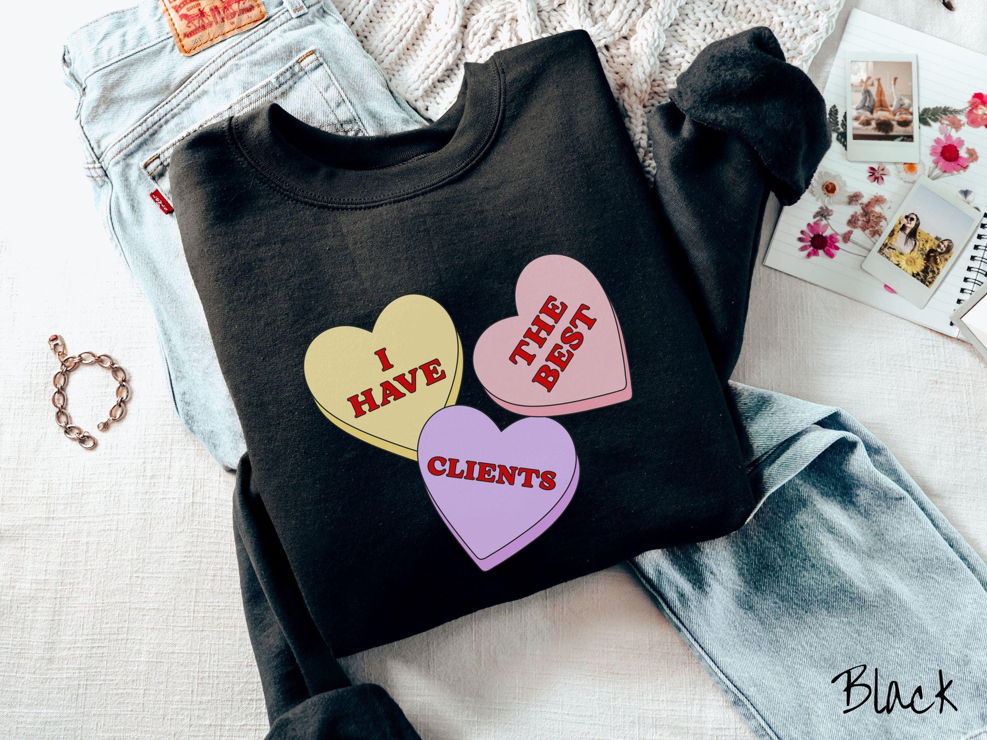 Show your appreciation for your amazing clients with this charming Gildan sweatshirt featuring three vibrant conversation hearts in yellow, red, and purple colors showcasing the text “I have the best clients” spread across the hearts.