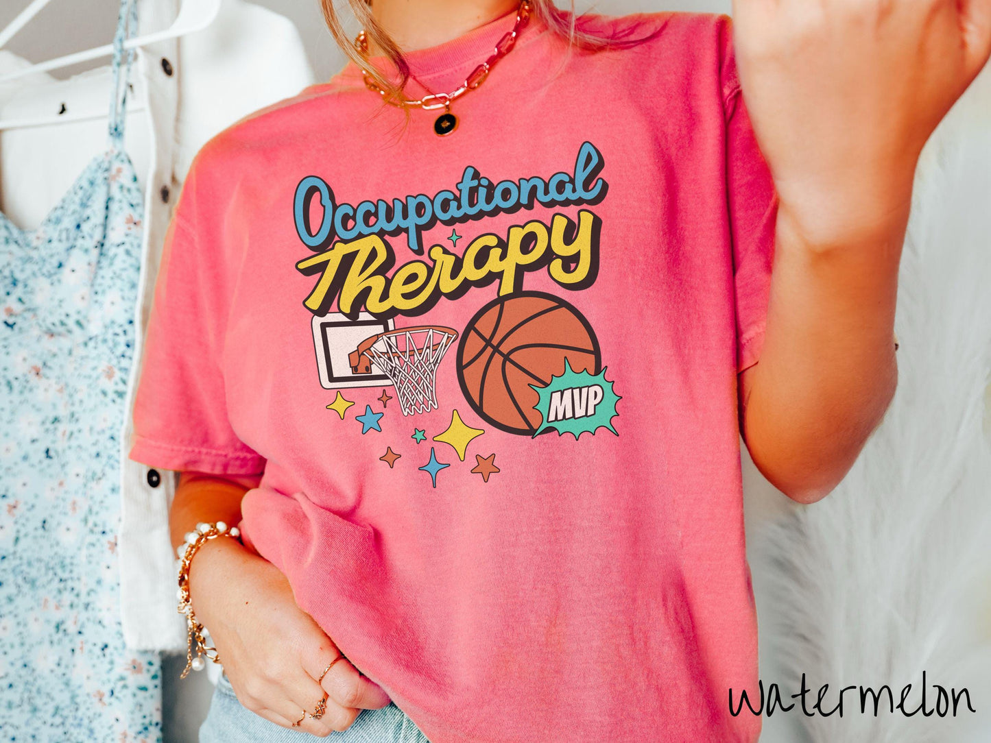 A vintage, watermelon colored Comfort Colors T-Shirt features the phrase "Occupational Therapy" above a basketball goal, complemented by a bold basketball graphic with the text "MVP".