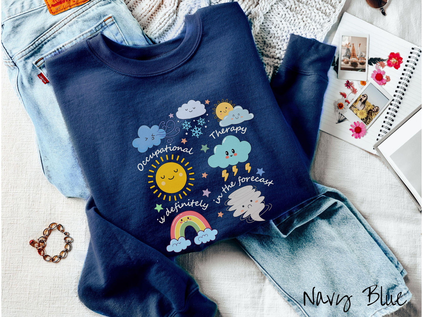 A vintage, navy blue colored Gildan sweatshirt featuring the text Occupational Therapy is definitely in the forecast and surrounded by weather elements like clouds, rain clouds, a shining sun, lightning, a rainbow, and a tornado.