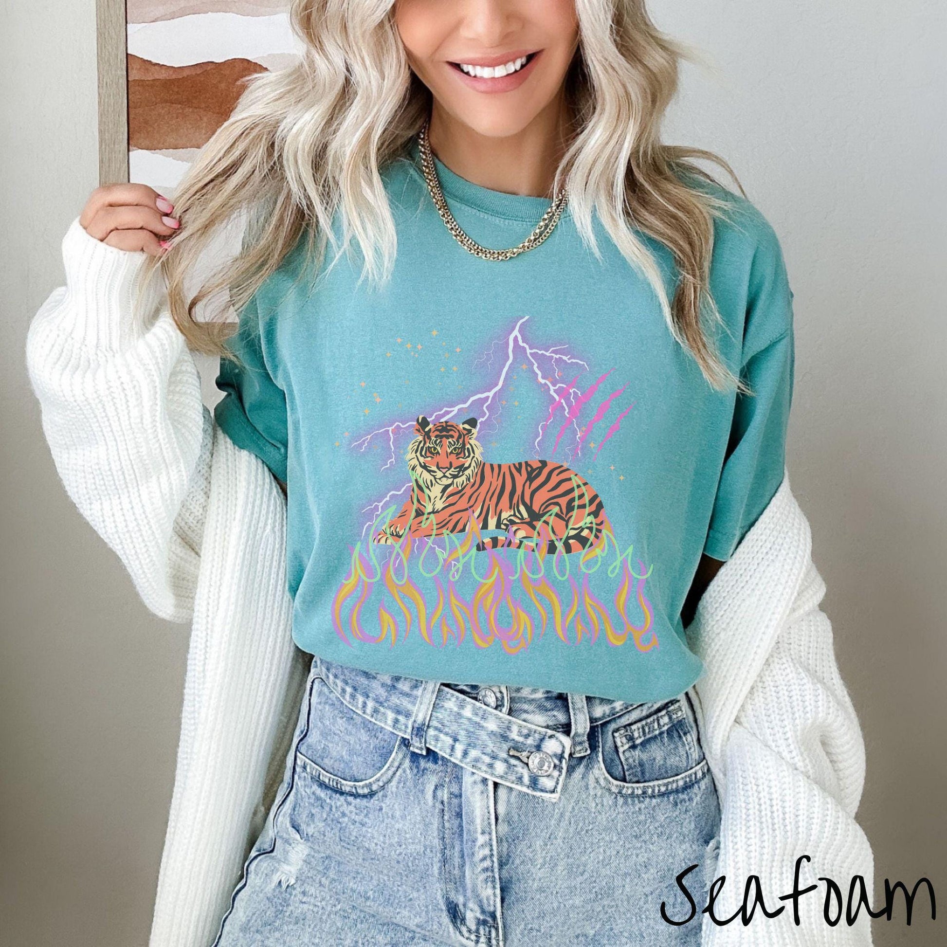 A vintage Comfort Colors t-shirt with a majestic tiger design above colorful flames and lightning. The relaxed fit and classic crew neckline make it perfect for casual or semi-formal wear.