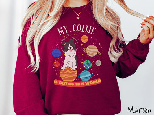 A vintage Gildan sweatshirt featuring the text My Collie is Out of This World. The design showcases an adorable Border Collie sitting proudly atop Jupiter, surrounded by a vibrant solar system filled with colorful planets and twinkling stars.