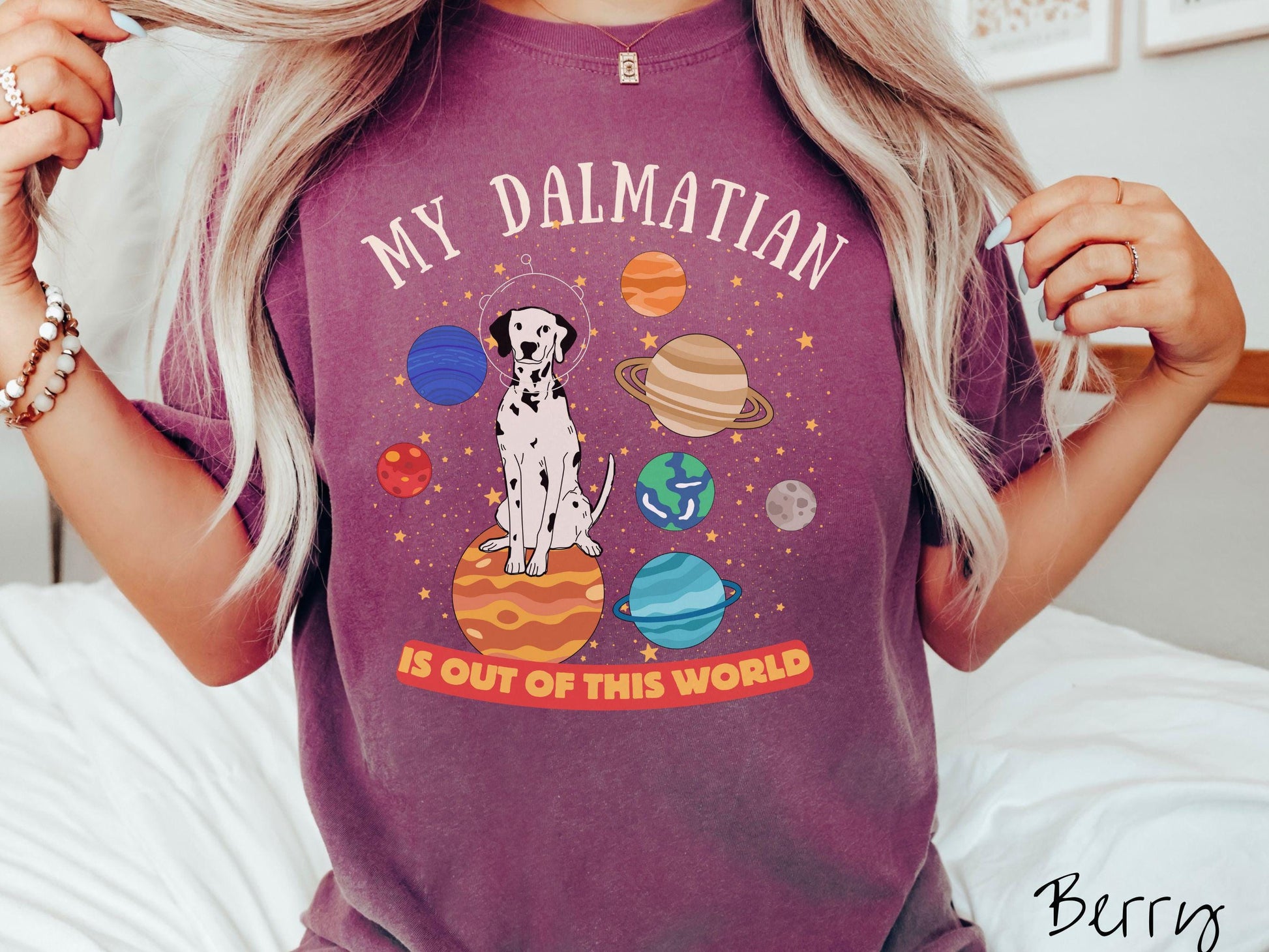 A vintage Comfort Colors t-shirt featuring the text My Dalmation is Out of This World. The design showcases a Dalmation sitting proudly atop Jupiter, surrounded by a vibrant solar system filled with colorful planets and twinkling stars.