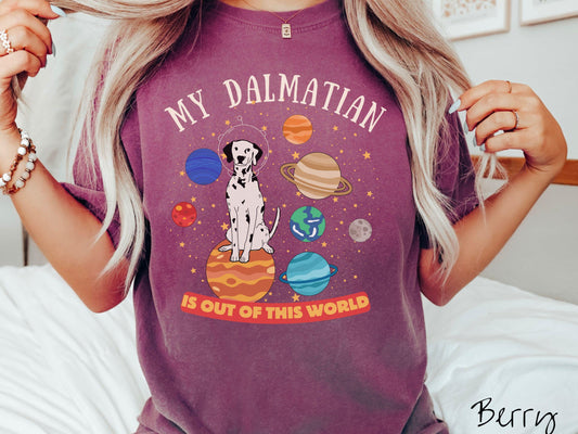 A vintage Comfort Colors t-shirt featuring the text My Dalmation is Out of This World. The design showcases a Dalmation sitting proudly atop Jupiter, surrounded by a vibrant solar system filled with colorful planets and twinkling stars.