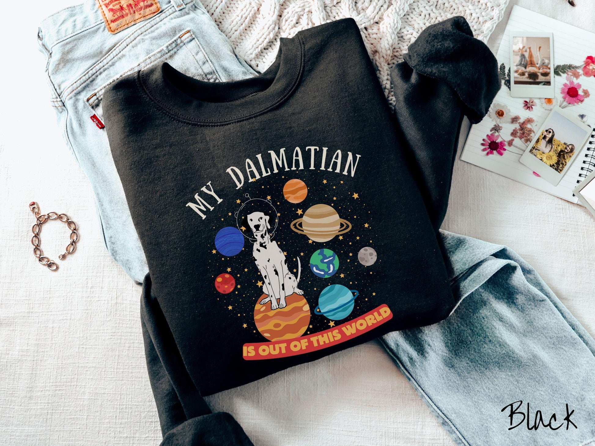 A vintage Gildan sweatshirt featuring the text My Dalmation is Out of This World. The design showcases a Dalmation sitting proudly atop Jupiter, surrounded by a vibrant solar system filled with colorful planets and twinkling stars.