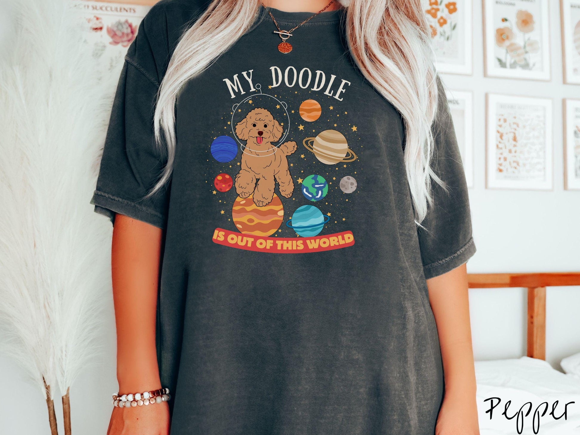 A vintage Comfort Colors t-shirt featuring the text My Doodle is Out of This World. The design showcases a Doodle sitting proudly atop Jupiter, surrounded by a vibrant solar system filled with colorful planets and twinkling stars.