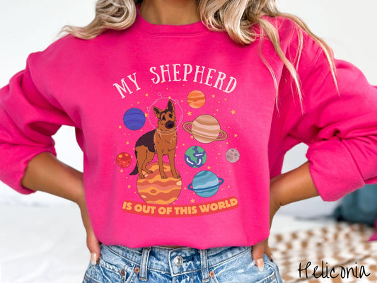 A vintage Gildan sweatshirt featuring the text My Shepherd is Out of This World. The design showcases a German Shepherd sitting proudly atop Jupiter, surrounded by a vibrant solar system filled with colorful planets and twinkling stars.