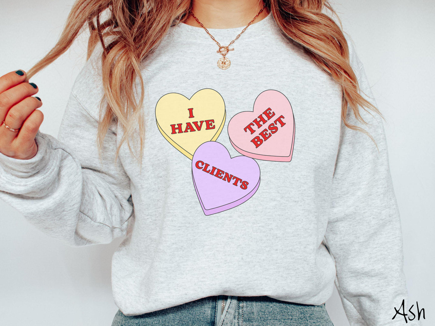Show your appreciation for your amazing clients with this charming Gildan sweatshirt featuring three vibrant conversation hearts in yellow, red, and purple colors showcasing the text “I have the best clients” spread across the hearts.