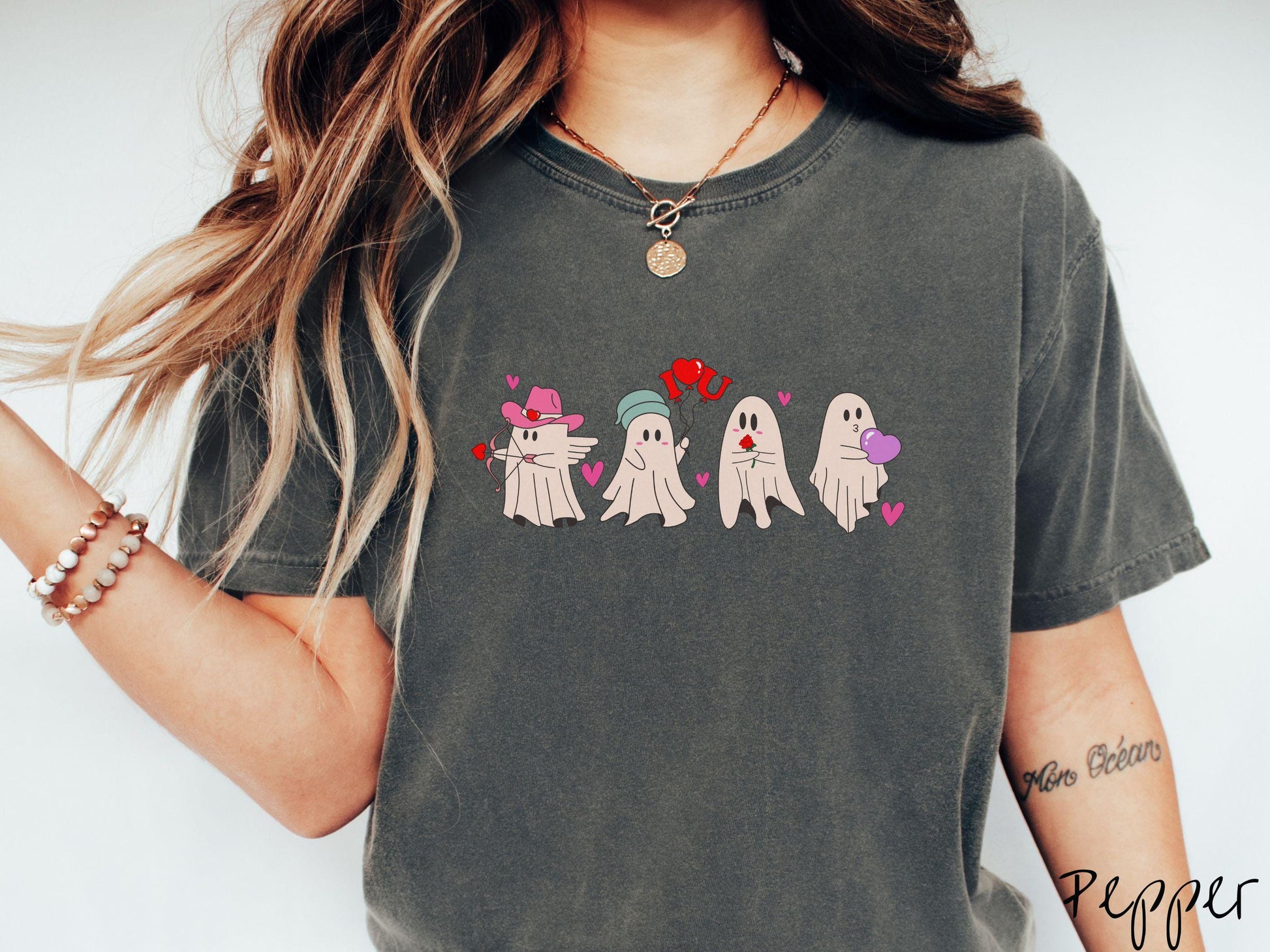 A vintage Comfort Colors t-shirt featuring four adorable ghosts with romantic details like a cowboy hat, heart-tipped arrows, &quot;I Love You&quot; balloons, a red rose, and a purple heart balloon, plus pink hearts for a whimsical touch.