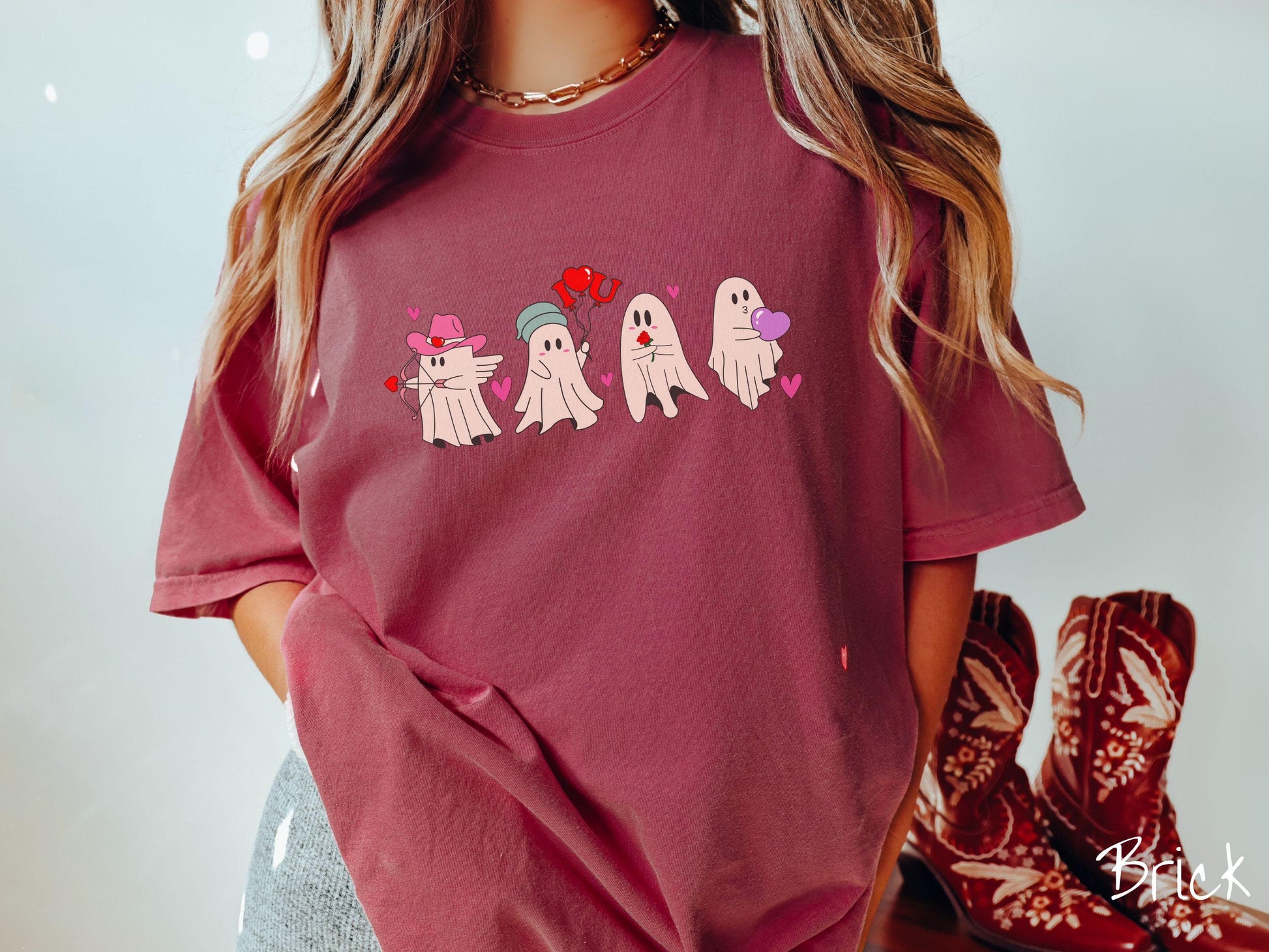 A vintage Comfort Colors t-shirt featuring four adorable ghosts with romantic details like a cowboy hat, heart-tipped arrows, &quot;I Love You&quot; balloons, a red rose, and a purple heart balloon, plus pink hearts for a whimsical touch.
