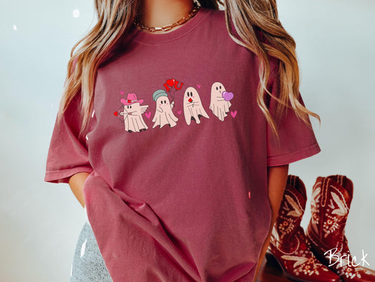 A vintage Comfort Colors t-shirt featuring four adorable ghosts with romantic details like a cowboy hat, heart-tipped arrows, &quot;I Love You&quot; balloons, a red rose, and a purple heart balloon, plus pink hearts for a whimsical touch.