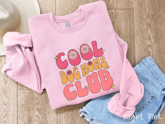 A vintage Gildan sweatshirt featuring the playful text Cool Dog Moms Club, this design is full of charming details. From flower petals nestled in the "O" of COOL to a cute red paw print in the "O" of DOG and sparkling yellow stars throughout.