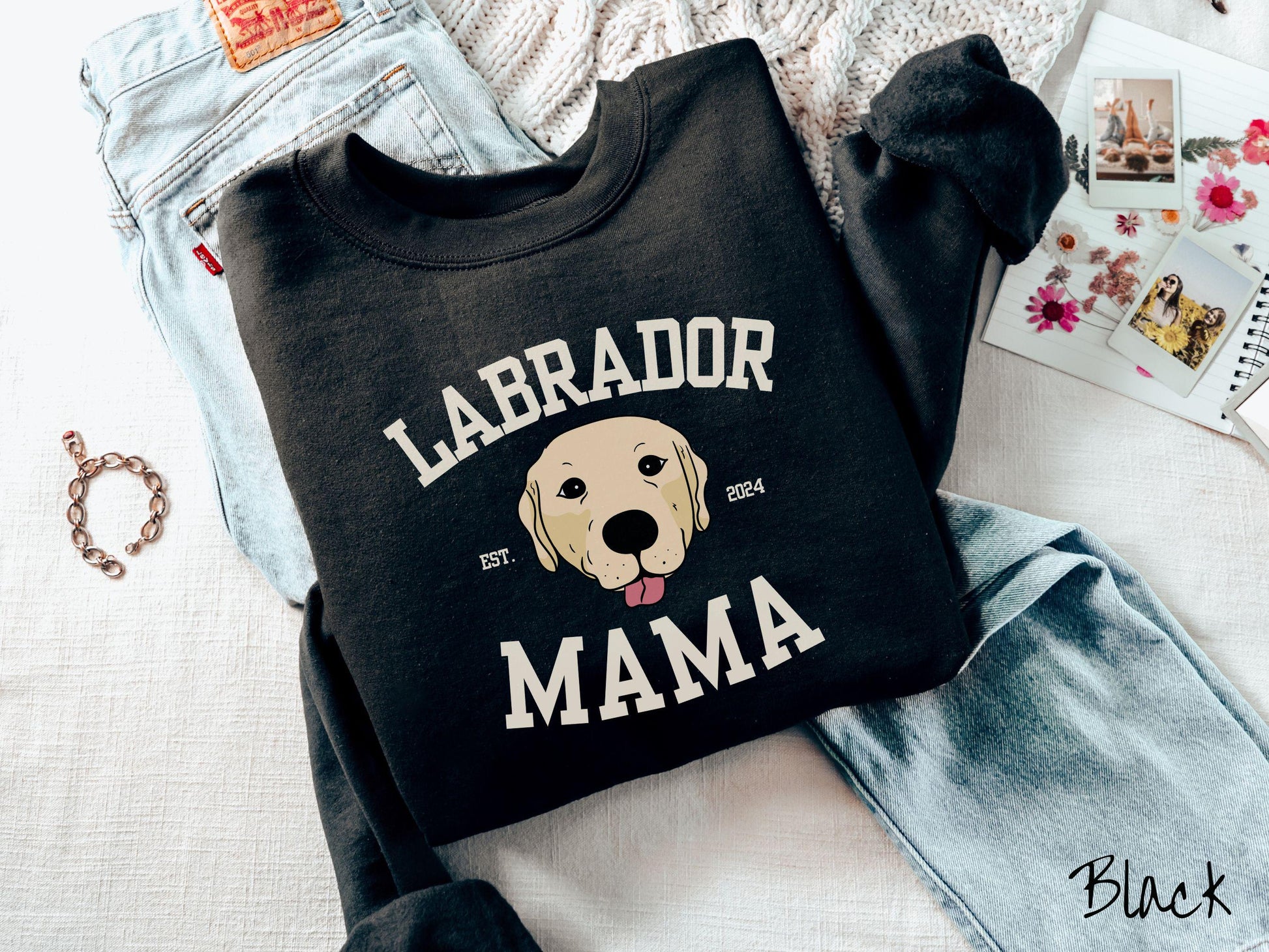 A vintage Gildan sweatshirt featuring bold block lettering that reads &#39;Labrador Mama.&#39; At the center of the design, a playful yellow Labrador with its tongue out steals the spotlight, framed by the stylish text &#39;EST. 2024.&#39;