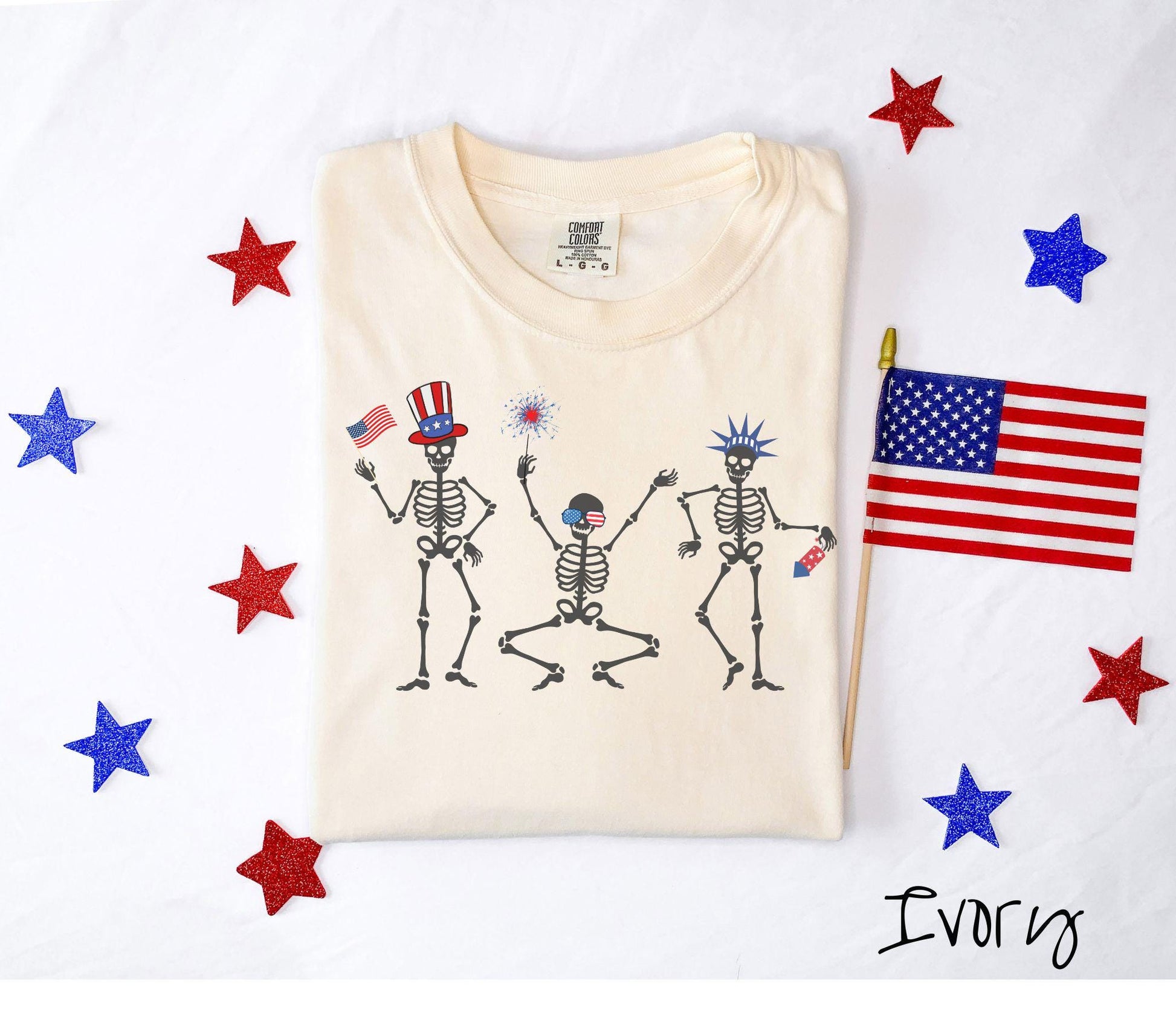 Celebrate in style with this vintage-inspired tee featuring three dancing skeletons decked out in red, white, and blue hats. They hold American flags, sparklers, and fireworks, making it the perfect shirt for Fourth of July celebrations.