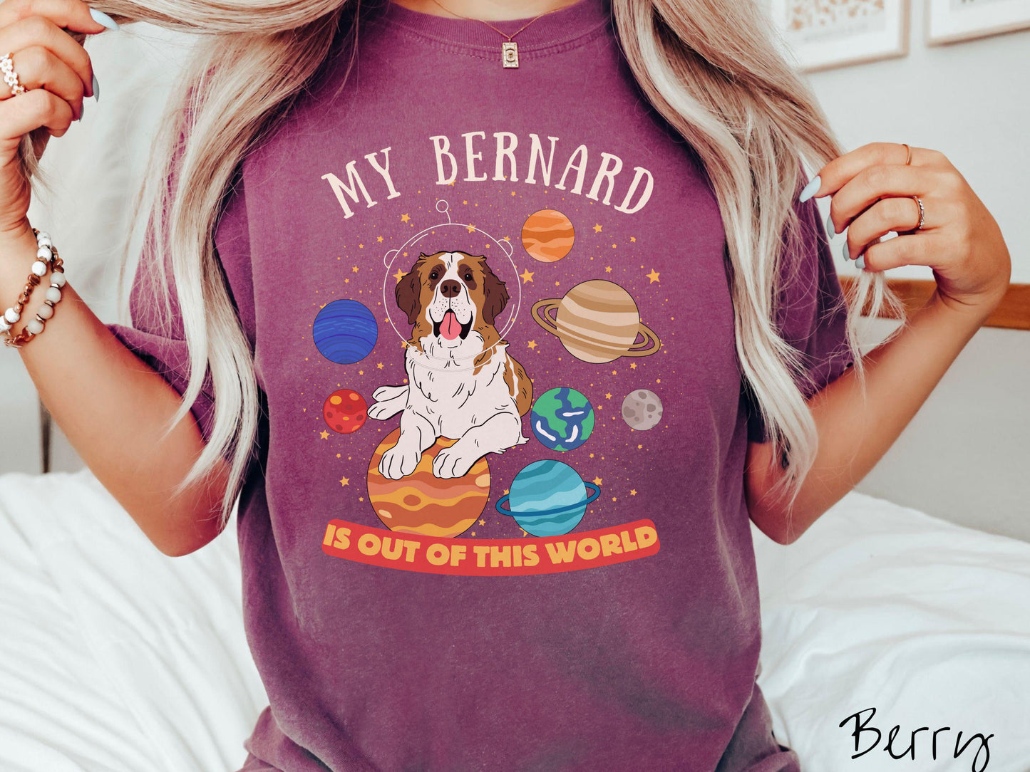 A vintage Comfort Colors t-shirt featuring the text 'My Bernard is Out of This World'. The design showcases an adorable St. Bernard sitting proudly atop Jupiter, surrounded by a vibrant solar system filled with colorful planets and twinkling stars.