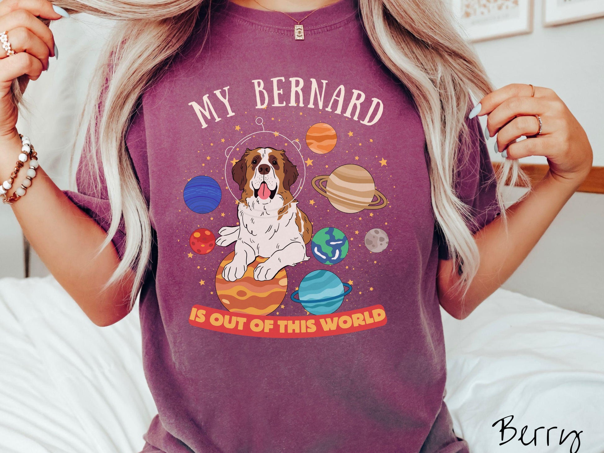 A vintage Comfort Colors t-shirt featuring the text 'My Bernard is Out of This World'. The design showcases an adorable St. Bernard sitting proudly atop Jupiter, surrounded by a vibrant solar system filled with colorful planets and twinkling stars.