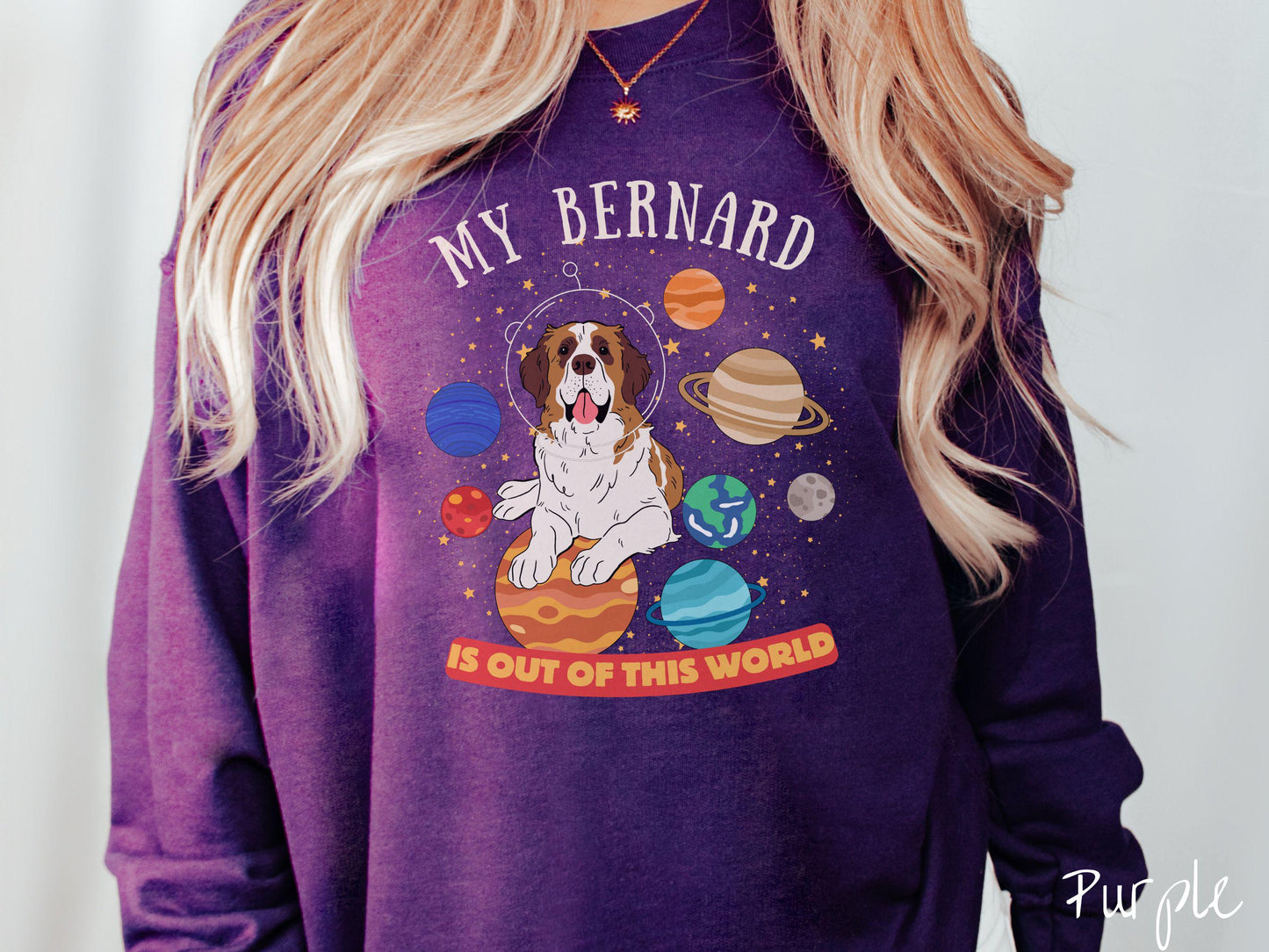 A vintage Gildan sweatshirt featuring the text 'My Bernard is Out of This World'. The design showcases an adorable St. Bernard sitting proudly atop Jupiter, surrounded by a vibrant solar system filled with colorful planets and twinkling stars.