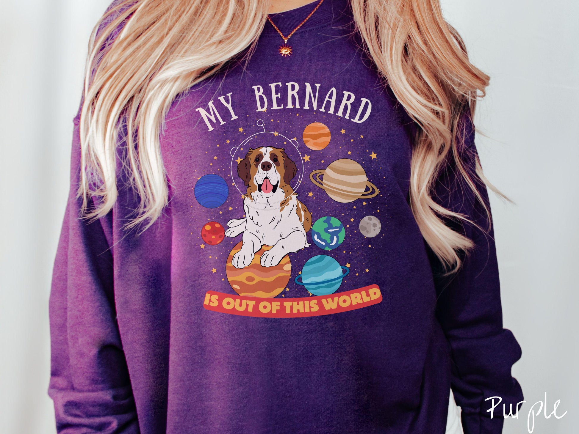 A vintage Gildan sweatshirt featuring the text 'My Bernard is Out of This World'. The design showcases an adorable St. Bernard sitting proudly atop Jupiter, surrounded by a vibrant solar system filled with colorful planets and twinkling stars.