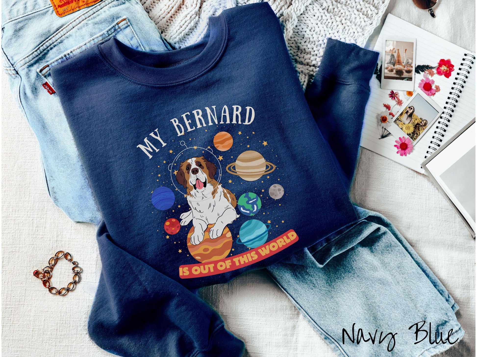 A vintage Gildan sweatshirt featuring the text &#39;My Bernard is Out of This World&#39;. The design showcases an adorable St. Bernard sitting proudly atop Jupiter, surrounded by a vibrant solar system filled with colorful planets and twinkling stars.
