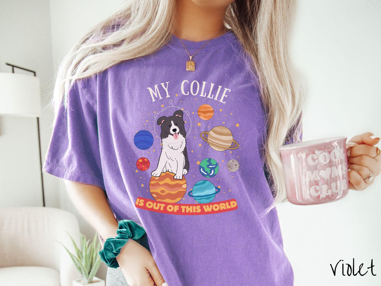 A vintage Comfort Colors t-shirt featuring the text My Collie is Out of This World. The design showcases an adorable Border Collie sitting proudly atop Jupiter, surrounded by a vibrant solar system filled with colorful planets and twinkling stars.