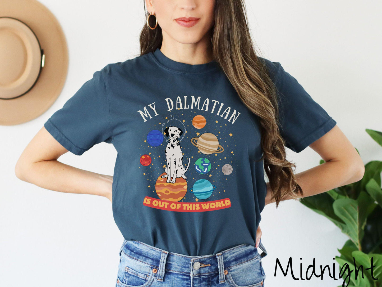 A vintage Comfort Colors t-shirt featuring the text My Dalmation is Out of This World. The design showcases a Dalmation sitting proudly atop Jupiter, surrounded by a vibrant solar system filled with colorful planets and twinkling stars.