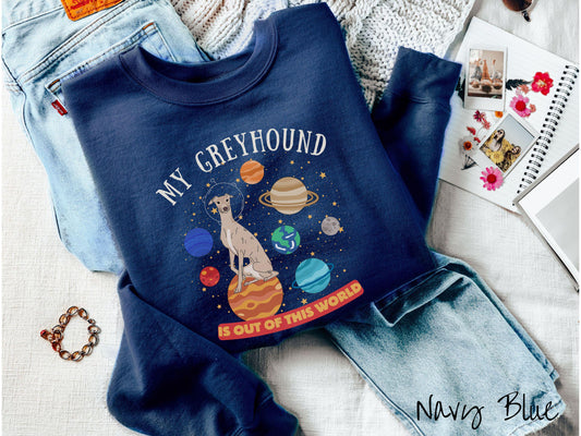 A vintage Gildan sweatshirt featuring the text My Greyhound is Out of This World. The design showcases a Greyhound sitting proudly atop Jupiter, surrounded by a vibrant solar system filled with colorful planets and twinkling stars.