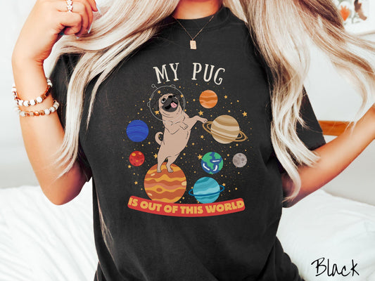 A vintage Comfort Colors t-shirt featuring the text My Pug is Out of This World. The design showcases an adorable Pug sitting proudly atop Jupiter, surrounded by a vibrant solar system filled with colorful planets and twinkling stars.