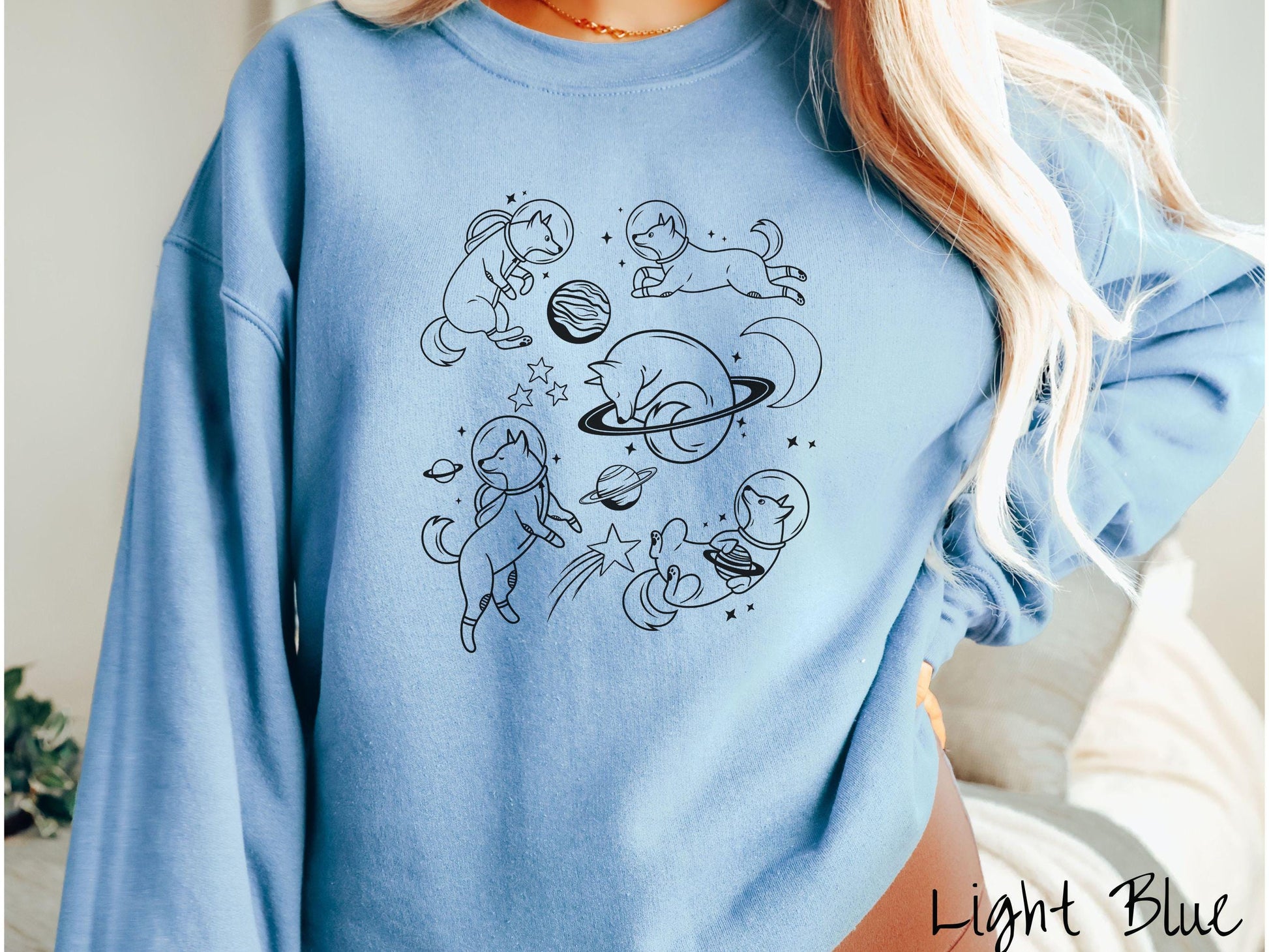 A vintage Gildan sweatshirt perfect for dog lovers and space enthusiasts alike, featuring outline designs of dogs in astronaut bubble helmets. This design showcases pups floating in the solar system, surrounded by stars, the moon, and planets.