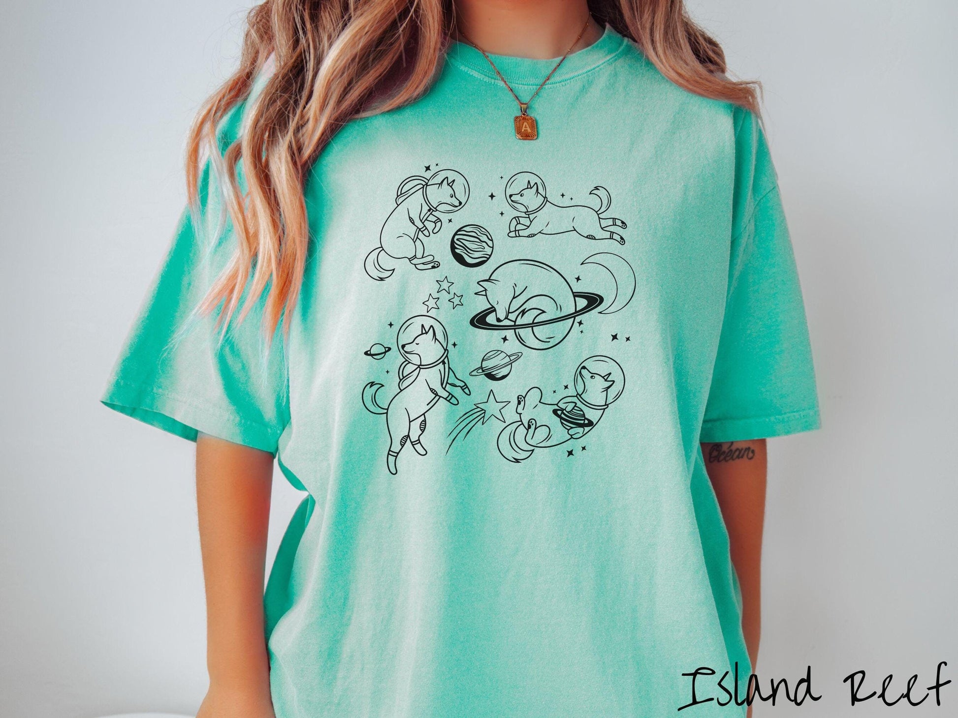 A vintage Comfort Colors t-shirt perfect for dog lovers and space enthusiasts alike, featuring outline designs of dogs in astronaut bubble helmets. This design showcases pups floating in the solar system, surrounded by stars, the moon, and planets.